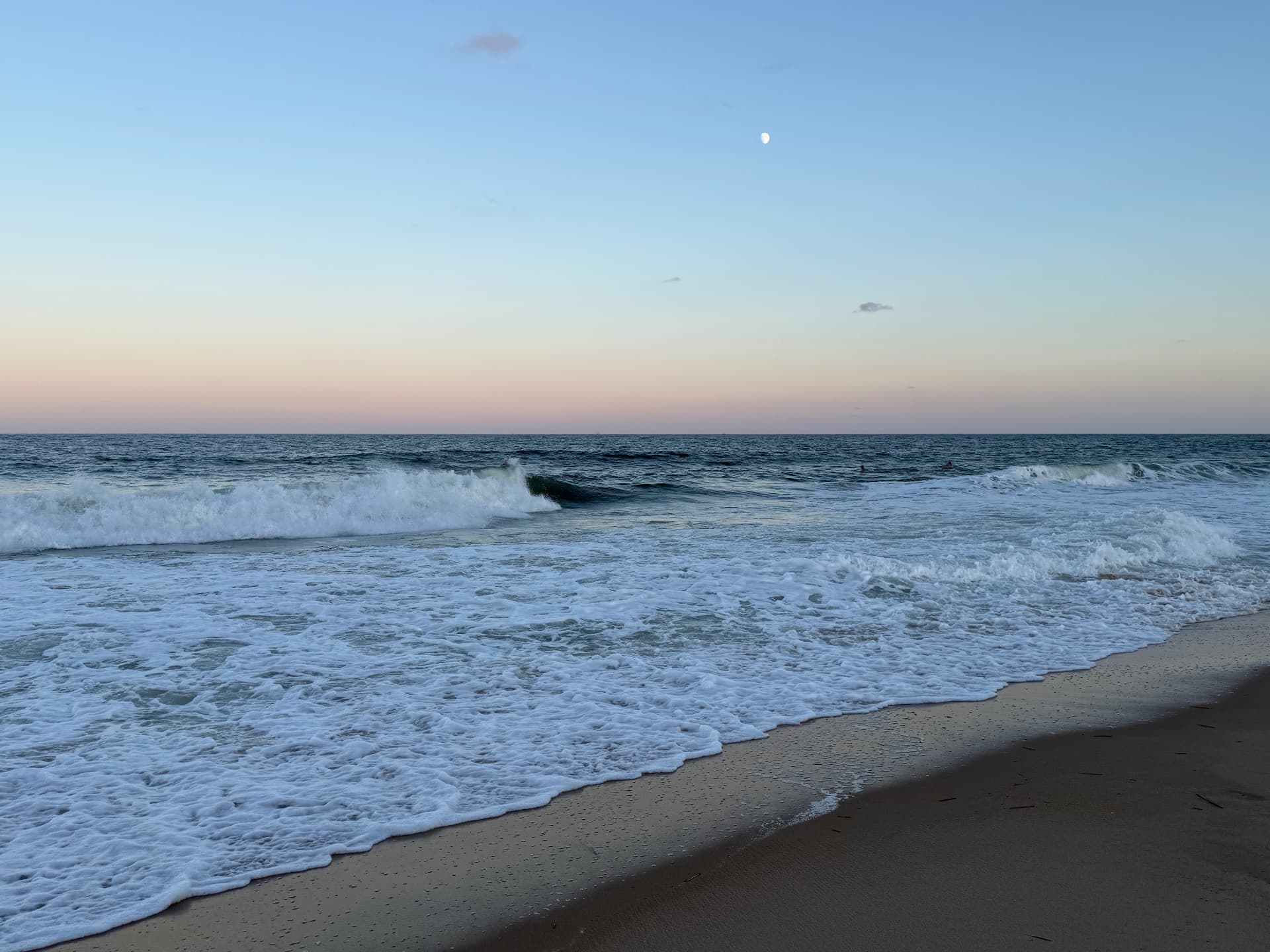 Sea foam washing up the sand at dusk in Ocean City, Maryland
