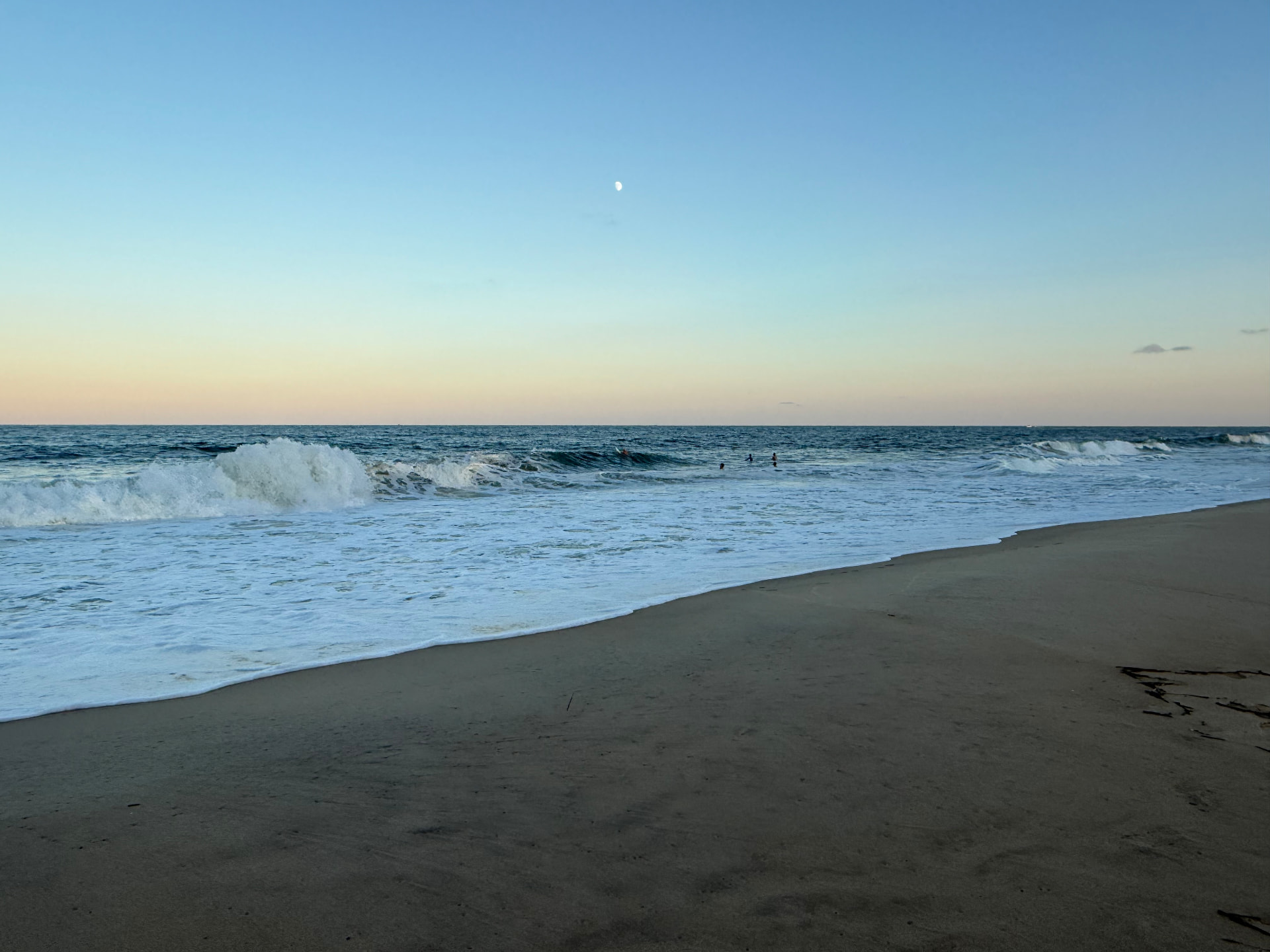 Waves breaking at dusk under a rising moon on the Ocean City, Maryland beach